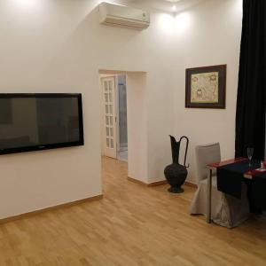 ein Wohnzimmer mit einem Flachbild-TV an der Wand in der Unterkunft La dimora dei borbone in Neapel