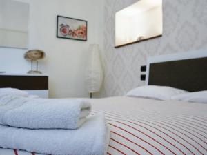 una camera da letto con un letto e asciugamani di La Casetta di Nonna Pina - Appartamento con cucina in pieno centro a Torre Annunziata