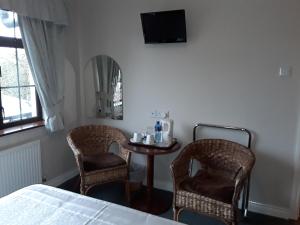 1 dormitorio con mesa, 2 sillas y 1 cama en Riverview House, en Athlone