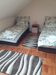 two beds in a room with two rugs at Tokaj vendégház in Tokaj
