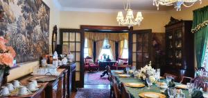 a dining room with a long table with a green table cloth at A Night to Remember B & B in Niagara Falls