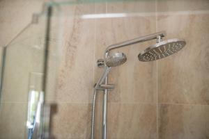 a shower stall with a glass shower door at Lomond Lodge Motel & Apartments in Queenstown