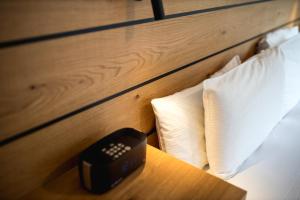 un reloj despertador negro sentado en una mesa junto a una cama en Lomond Lodge Motel & Apartments, en Queenstown 73 fotos más