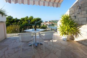 a patio with a table and chairs on a balcony at VILLA MILENKA - Apartmani Gorana in Tučepi