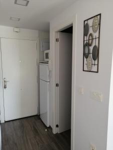 a kitchen with a white door and a refrigerator at Estudio FARO TORROX-1ª línea playa in Torrox Costa