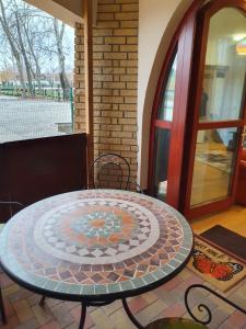 a table with a mosaic top on a patio at Lido Dalma Apartman 2 in Fonyód