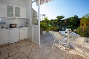 a kitchen with a table and chairs on a patio at VILLA MILENKA - Apartmani Gorana in Tučepi