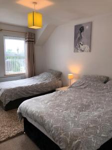 a bedroom with two beds and a window at Glendona Lodge in Glenavy