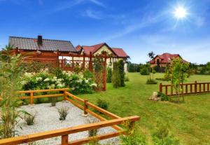 un patio con una valla de madera y una casa en Ferienhaus Franziska, en Kołobrzeg