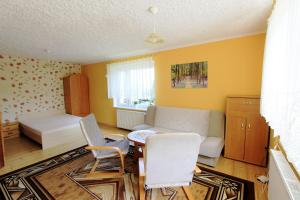 a living room with a couch and a table and chairs at Agroturystyka Lucyna Babińska in Radków