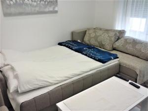 a couch with a blue pillow on top of it at Apartman Veljic in Niš