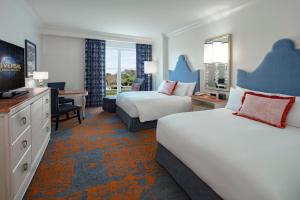 ein Hotelzimmer mit 2 Betten und einem TV in der Unterkunft Universal's Loews Portofino Bay Hotel in Orlando
