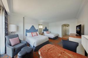 ein Hotelzimmer mit einem Bett, einem Sofa und einem Stuhl in der Unterkunft Universal's Loews Portofino Bay Hotel in Orlando