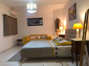 a bedroom with a bed and a couch at Cosy appart en plein coeur de la Marsa in La Marsa