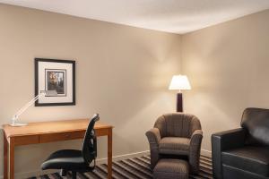 a hotel room with a desk and two chairs at Royal Hotel West Edmonton, Trademark Collection by Wyndham in Edmonton