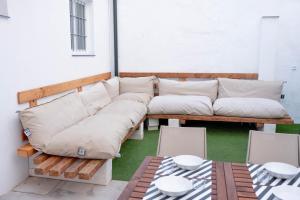 a wooden couch with pillows on a patio at Casa Juan Breva in Málaga