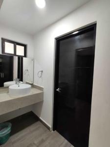 baño con puerta negra y lavamanos en Hotel Galería del Ángel, en Santa Cruz Huatulco