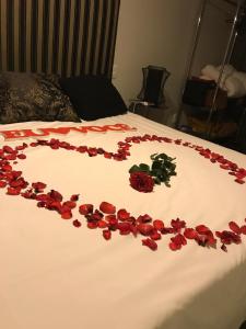 Ein Haufen roter Rosen auf dem Bett in der Unterkunft Pousada Charme e Estilo in Nova Petrópolis