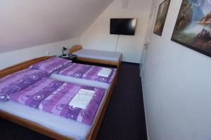 a bedroom with a bed with a purple comforter at Penzion K in Rudník
