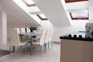 ein Esszimmer mit einem Tisch und weißen Stühlen in der Unterkunft MK Apartment 100m2 Friends&Family in Krakau + 5 Fotos