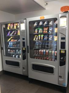 duas máquinas de venda automática com bebidas e refrigerantes numa loja em Hotel Hi! Queretaro em Querétaro