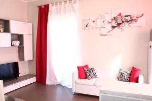 sala de estar con sofá blanco y cortinas rojas en Gioia House, en Torretta