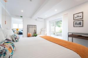 a large white bedroom with a large bed and a window at Duques Villa Luxury Guesthouse in Lisbon