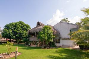a house with a thatched roof and a yard at Casa Finca La Catalina in Montería