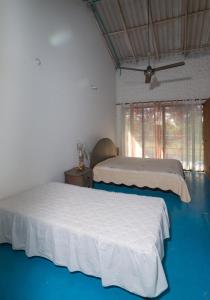 two beds in a bedroom with blue flooring at Casa Finca La Catalina in Montería