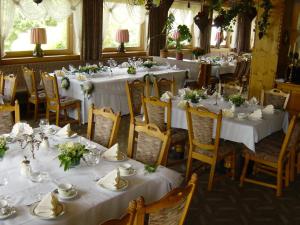 un comedor con mesas y sillas con mesas blancas en Landhotel Rappenhof, en Arnbruck
