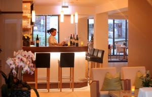 a woman standing at a bar in a restaurant at Wiedemann's Weinhotel in Sankt Martin