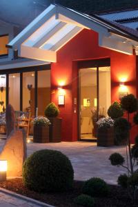 a house with a red wall with a glass door at Wiedemann's Weinhotel in Sankt Martin