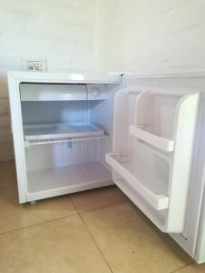 een lege witte koelkast met open deur bij Posada Del Cielo in Luján