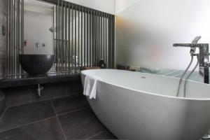 uma casa de banho com uma banheira branca e um lavatório. em SR Hotel Seoul Magok em Seul