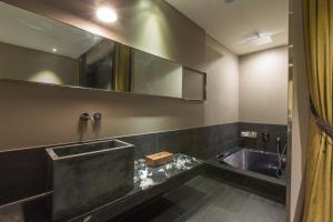 uma casa de banho com uma banheira e um espelho grande em SR Hotel Seoul Magok em Seul