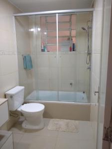 a bathroom with a shower and a toilet and a tub at Quarto exclusivo em APTO compartilhado in Novo Hamburgo