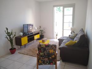 a living room with a couch and a tv at Quarto exclusivo em APTO compartilhado in Novo Hamburgo