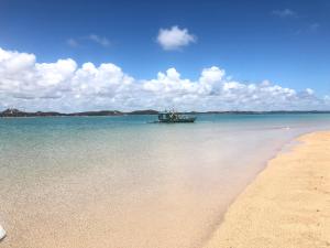 a boat in the water next to a beach at POUSADA MARITIMAR in Maragogi