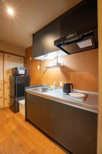 a kitchen with a sink and a refrigerator at marutto Ishikawa in Kanazawa