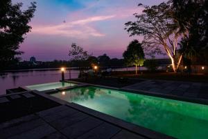 una piscina por la noche con las luces encendidas en Anaya's Lake House, en Kochi