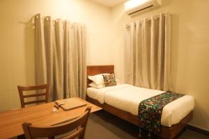 Habitación pequeña con cama y mesa con mesa en Anaya's Lake House, en Kochi