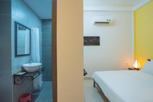a bathroom with a bed and a sink in a room at Old Lane Homestay in Hoi An +28 photos