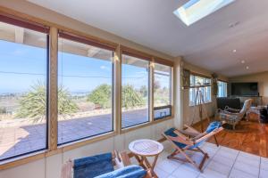 a living room with chairs and windows with a view at Nautical Escape in Eureka