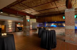 um quarto com mesas pretas e uma parede de tijolos em Crowne Plaza Indianapolis-Dwtn-Union Stn, an IHG Hotel em Indianápolis