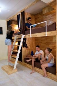 a group of people sitting in bunk beds in a room at Coco Khao Sok Hostel in Khao Sok