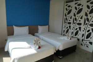 two beds in a room with two rabbits on them at S4 Nai Yang Beach - SHA EXTRA PLUS in Nai Yang Beach