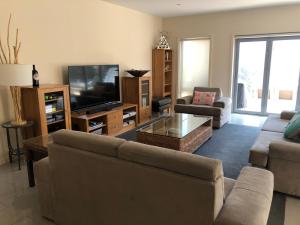 a living room with a couch and a tv at Residence On Robe in Robe