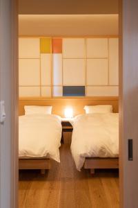 a room with two beds and a door to a bedroom at marutto Ishikawa in Kanazawa