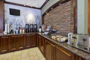 a kitchen with a counter and a stone wall at Staybridge Suites Lansing-Okemos by IHG in Okemos
