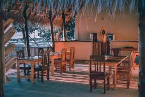 comedor con mesas y sillas de madera en Mulia Bungalows, en Nembrala